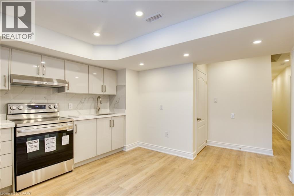 A kitchen with a stove top oven and cabinets.