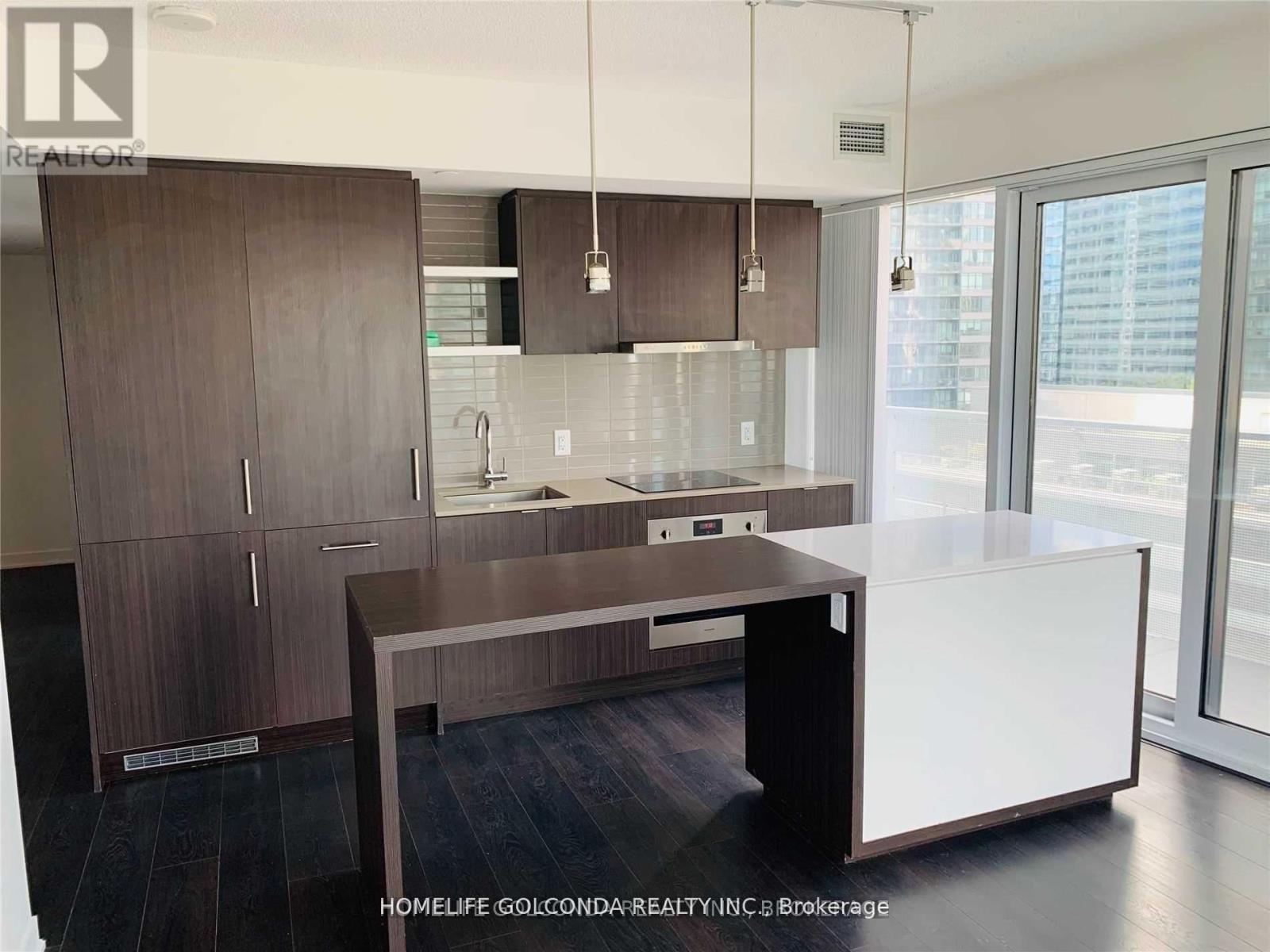 A modern kitchen with dark wood cabinets and a white island.