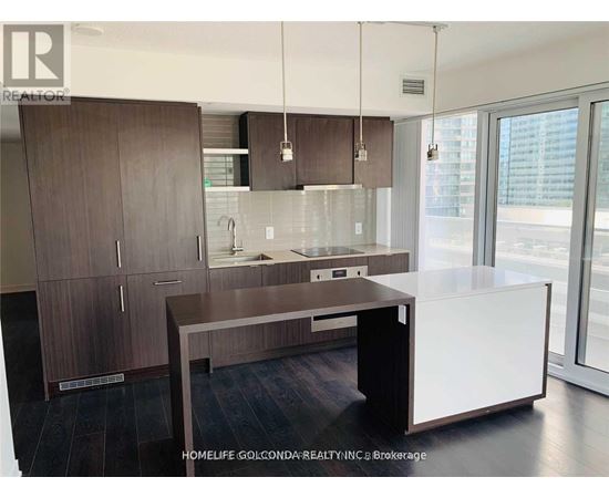 A modern kitchen with dark wood cabinets and a white island.