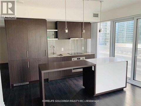 A modern kitchen with dark wood cabinets and a white island.