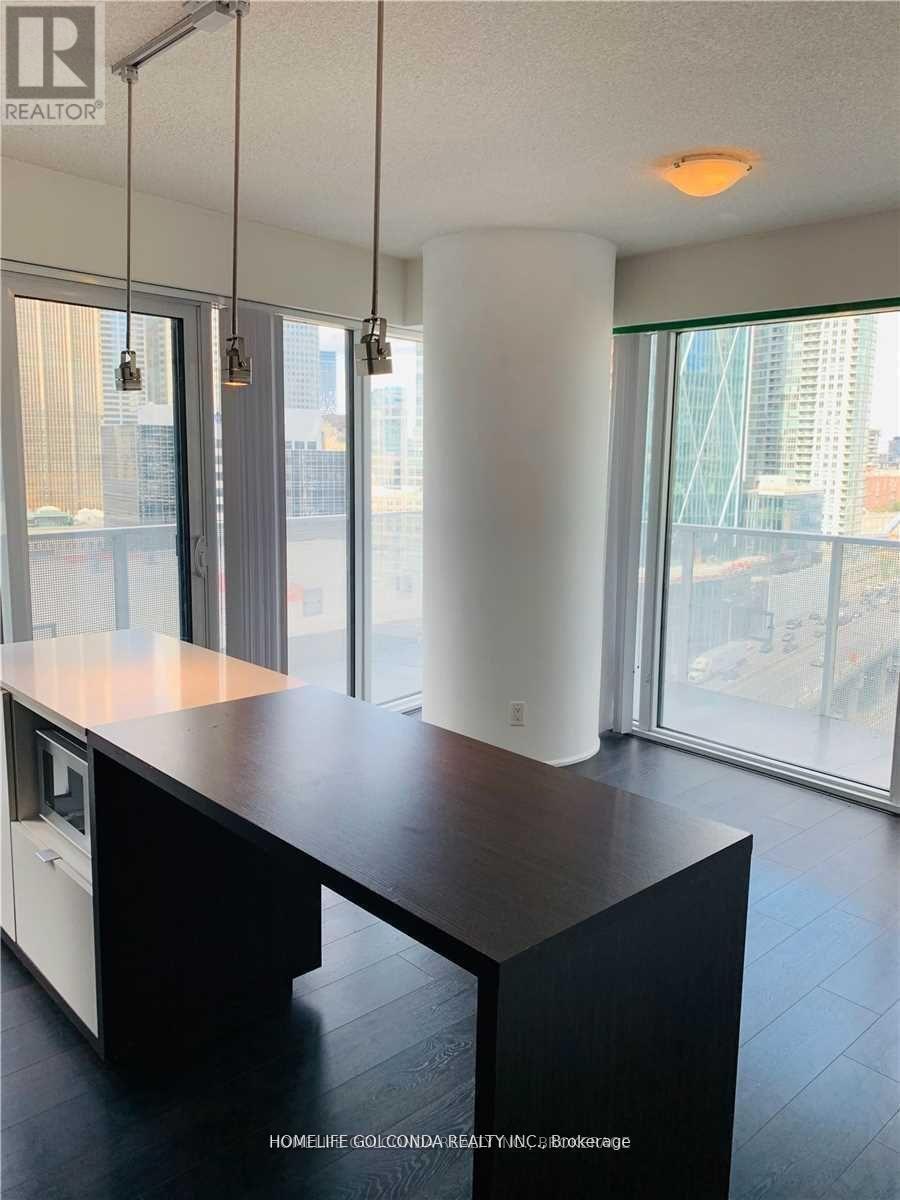 A modern kitchen with a large island and a view of the city.