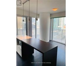 A modern kitchen with a large island and a view of the city.