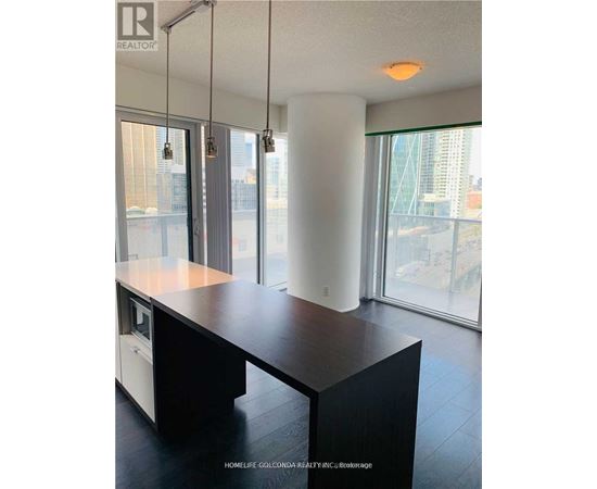 A modern kitchen with a large island and a view of the city.