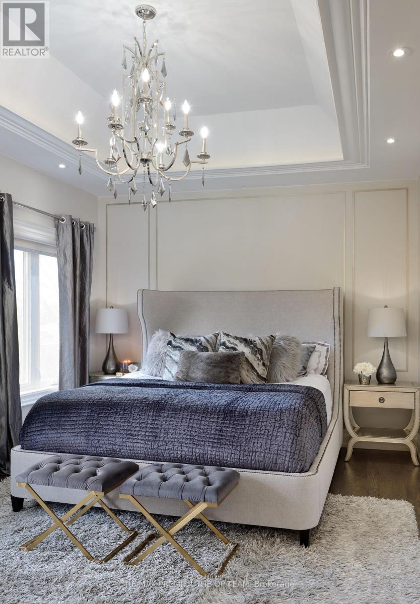 A bedroom with a large bed and a chandelier.