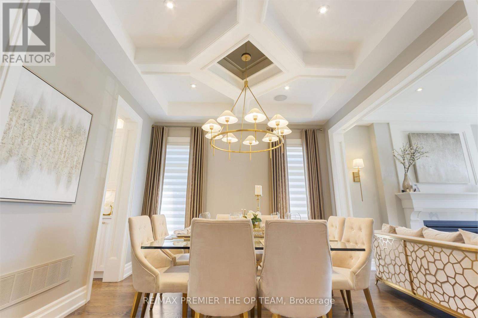 A dining room with a chandelier, a table with chairs, and a fireplace.