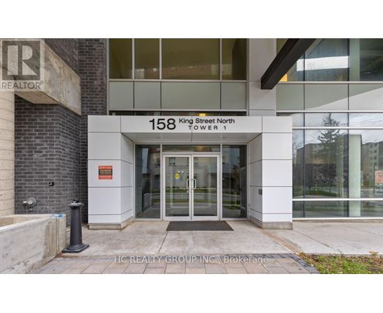 The front of a building with the sign "158 King Street North Tower 1" and a glass door entrance.