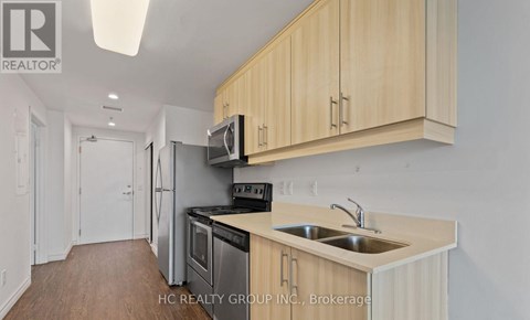 A kitchen with wooden cabinets and stainless steel appliances.