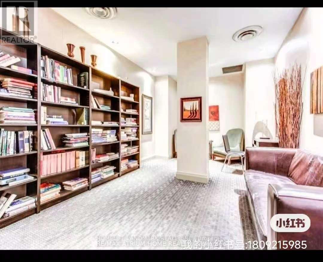A living room with a bookshelf filled with books and a couch.