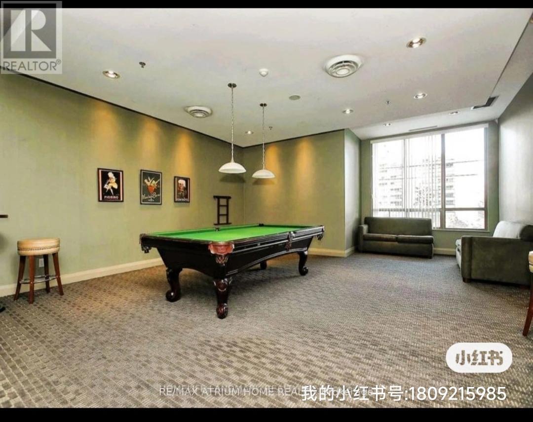 A room with a pool table and a green sofa.