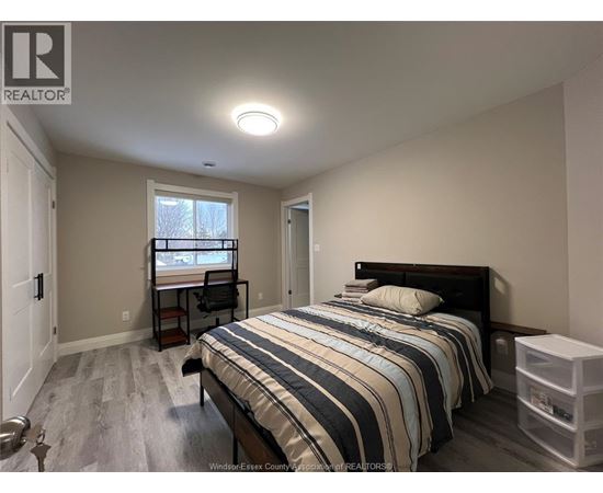 A bedroom with a bed, desk, and chair.