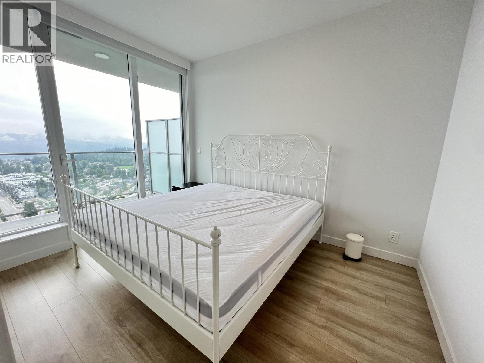 A bedroom with a large bed and a view of the city.