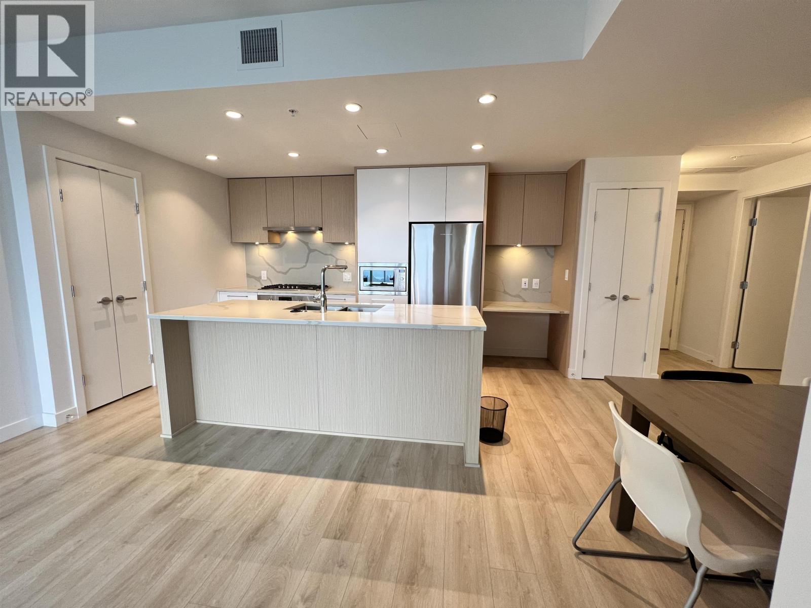 A kitchen with a white counter and a white chair.