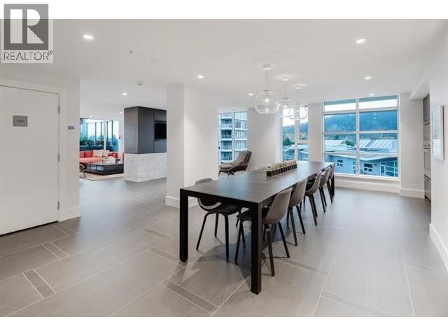 A modern dining room with a long table and chairs.