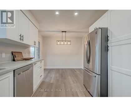 A modern kitchen with a refrigerator on the right and a dishwasher on the left.