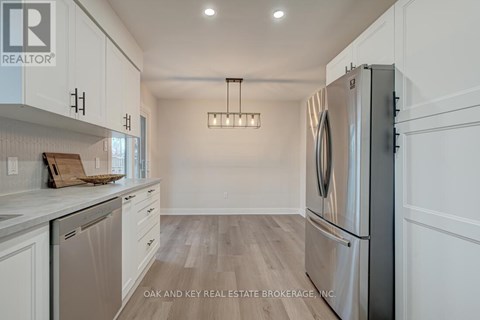 A modern kitchen with a refrigerator on the right and a dishwasher on the left.