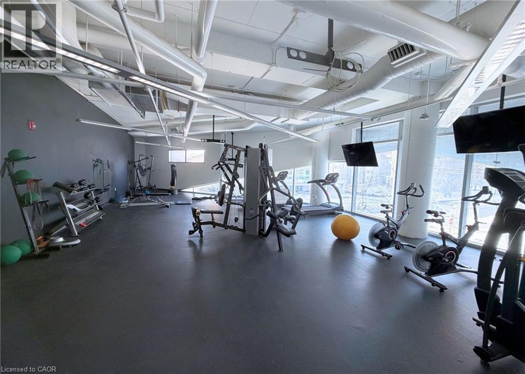 A gym with various exercise equipment and a large window.