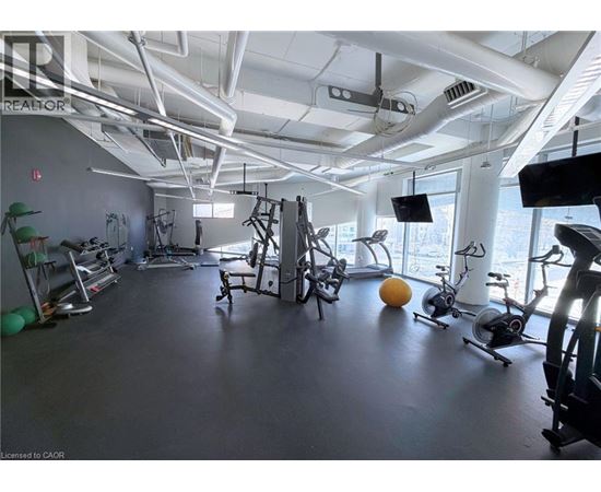 A gym with various exercise equipment and a large window.