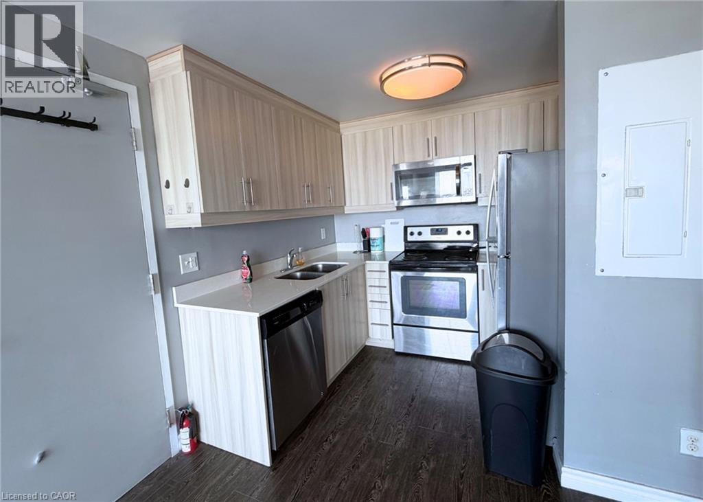 A kitchen with a refrigerator, oven, and sink.