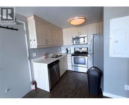 A kitchen with a refrigerator, oven, and sink.
