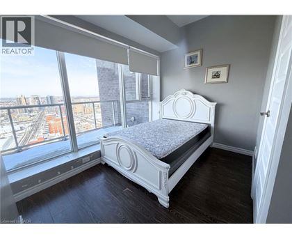 A bedroom with a large bed and a view of the city.