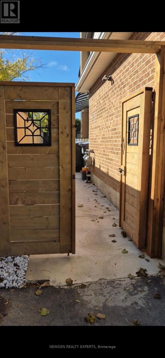 A wooden gate with a decorative window is the main focus of the image.