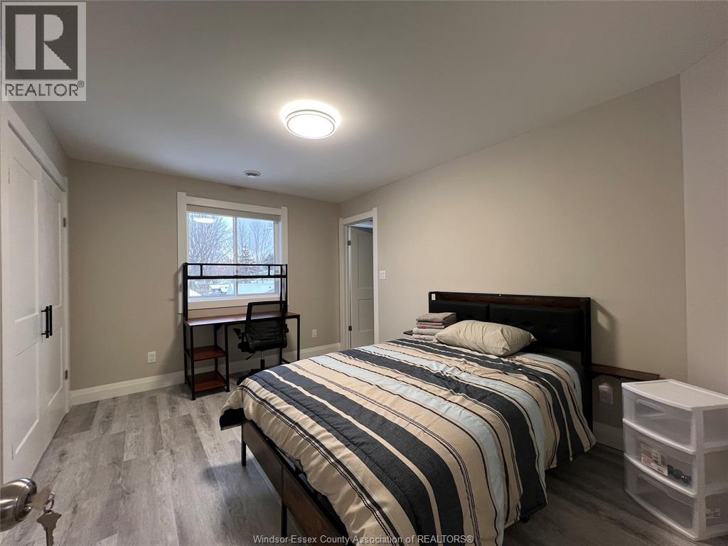 A bedroom with a bed, desk, and chair.