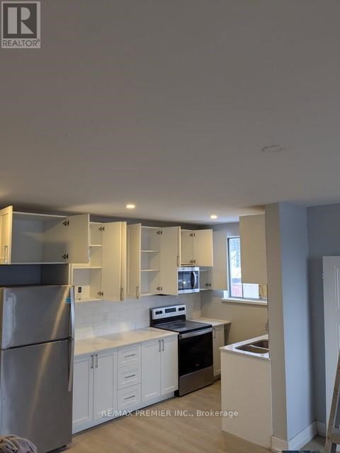 A kitchen with white cabinets and stainless steel appliances.