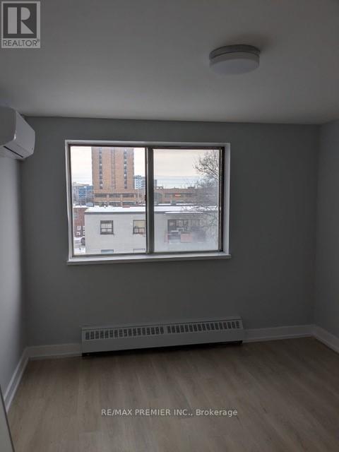 A room with a window showing a view of a cityscape.