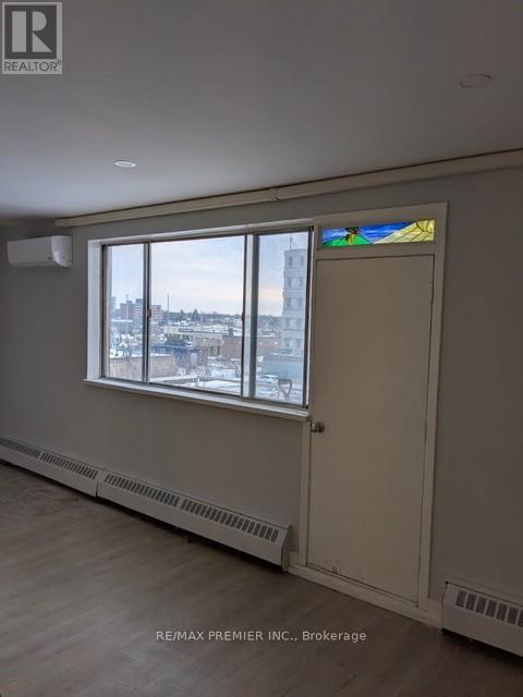 A room with a window that has a view of a city.