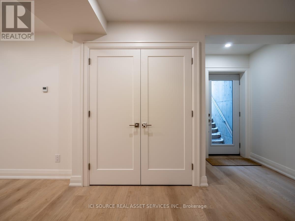 A white door with a glass window is in a room with wooden floors.