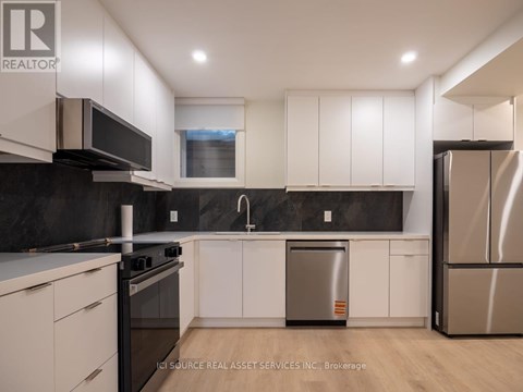 A modern kitchen with white cabinets and stainless steel appliances.