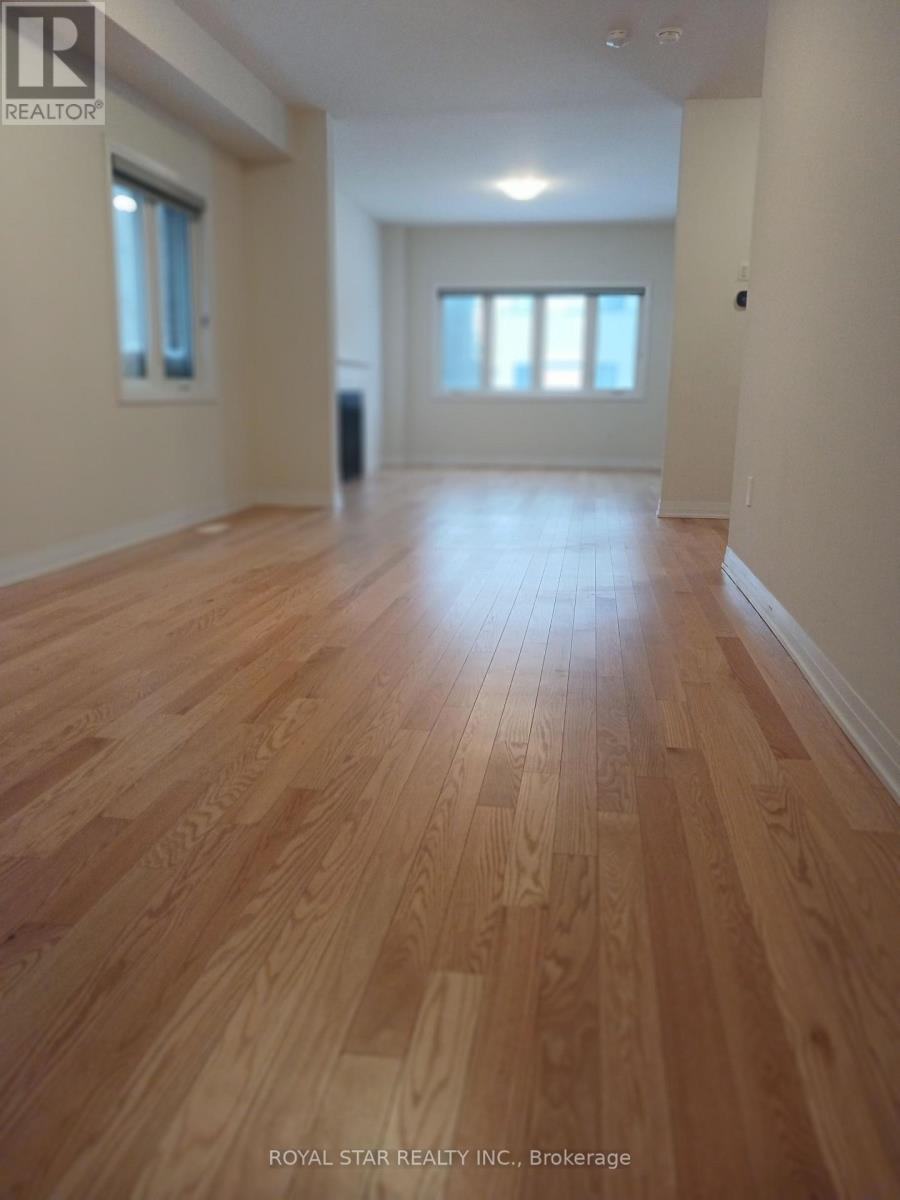 A spacious room with wooden flooring and white walls.