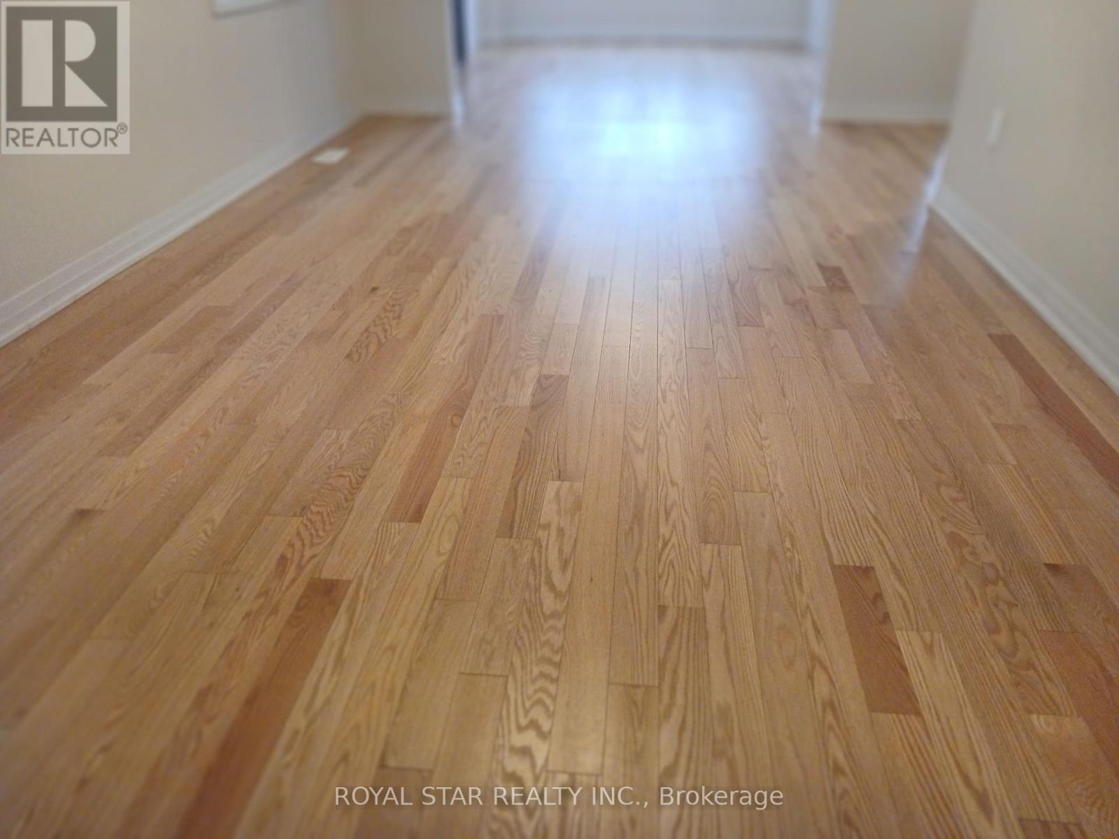 A wood floor in a room with Royal Star Realty Inc. logo.