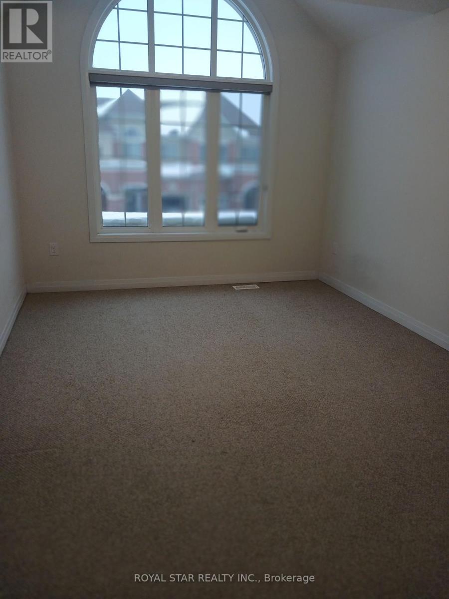 A carpeted room with a large window and a view of a building across the street.