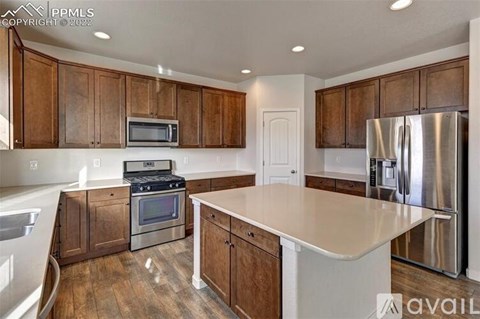 A kitchen with wooden cabinets and stainless steel appliances.