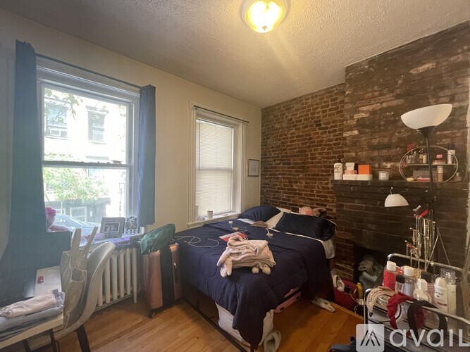 A bedroom with a bed, chair, and window.