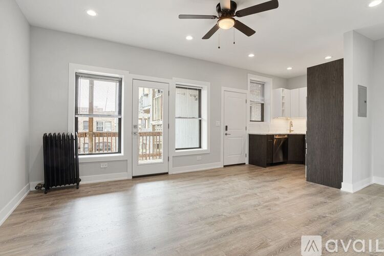 A spacious room with a ceiling fan and a radiator on the floor.
