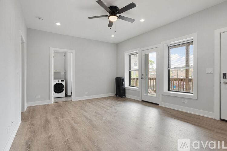 A spacious room with a ceiling fan and a washer and dryer.