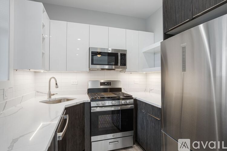 A modern kitchen with a stainless steel refrigerator and a white countertop.