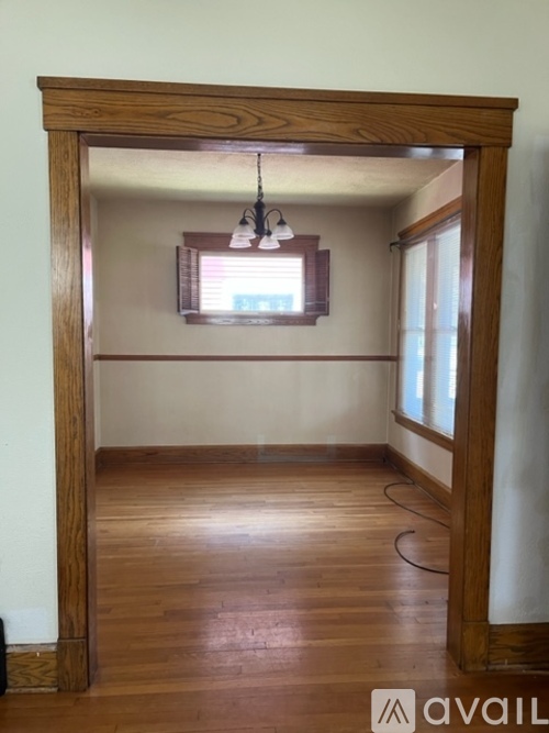 A room with wooden floors and a large wooden archway.