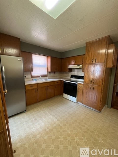A kitchen with wooden cabinets and a refrigerator.