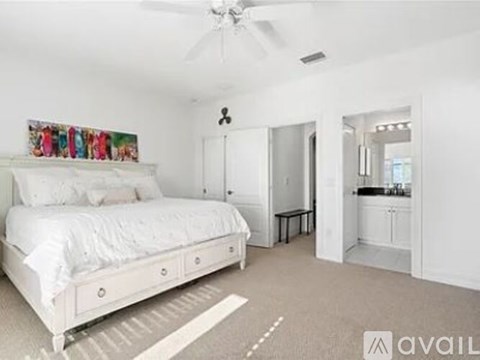 A bedroom with a large bed and a ceiling fan.