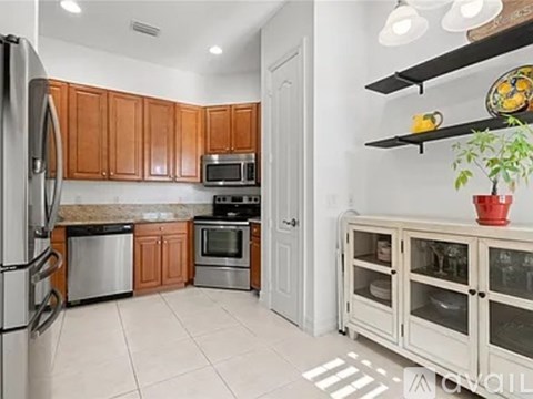 A kitchen with wooden cabinets and a refrigerator.