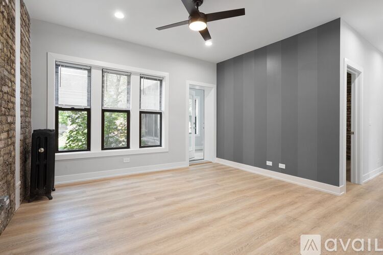 A room with a ceiling fan and wooden flooring.