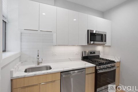 A modern kitchen with white cabinets and a stainless steel dishwasher.
