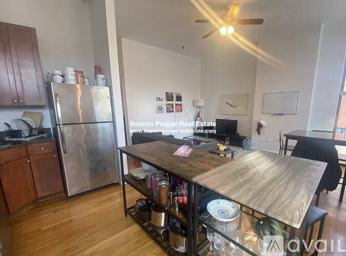 A kitchen with wooden cabinets and a stainless steel refrigerator.