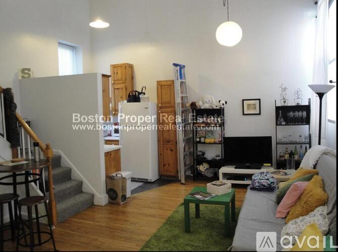 A living room with a couch, a coffee table, a TV, and a bookshelf.