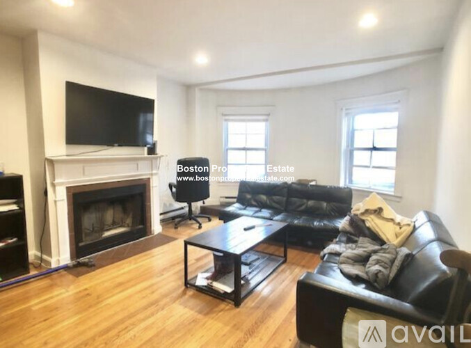 A living room with a fireplace and a television.