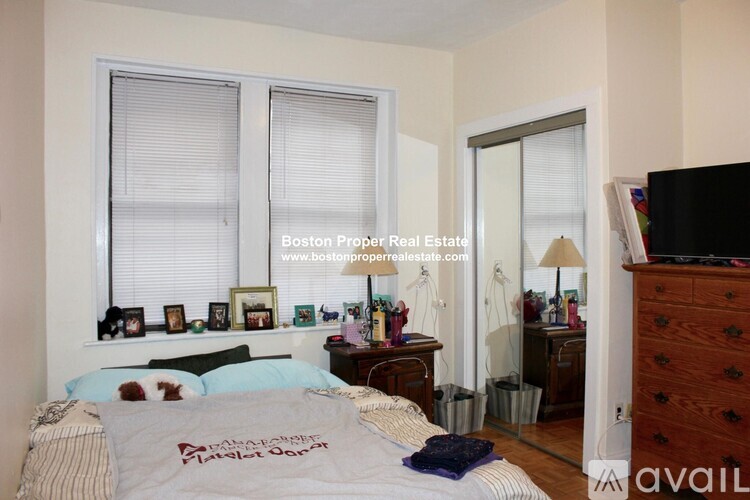 A bedroom with a bed, dresser, and window.
