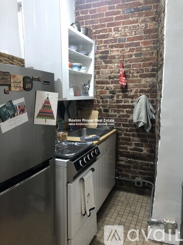 A kitchen with a refrigerator covered in magnets and a stove top oven.